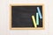 Pieces of chalk on a school blackboard on a white wooden background. Top view. Copy space