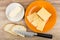 Pieces of cheese in orange plate, saucer with butter, bread