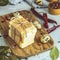 Pieces of cheese in paper on wooden board