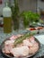 pieces of chicken and rabbit meat in a tray with a sprig of rosemary, ready to cook.