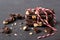 Pieces of chocolate with nuts tied with white and red decorative rope lie on a dark texture table