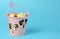 Pieces of chocolate in a pink bucket on a blue background
