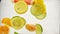 Pieces of citrus fruits mandarin, lime, lemon, orange, grapefruit fall into the water with spray and bubbles, slow