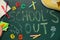 Pieces of color chalk, shoes and stationery on greenboard with text School`s Out, flat lay. Summer holidays