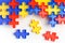 Pieces from a colorful jigsaw puzzle arranged to form a page on white background. Break barriers together for autism