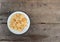 Pieces of crunchy dry Frico in a white plate on weathered wooden table. It is a traditional friulian snack.