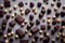 Pieces of dark bitter chocolate with chocolates and hazelnuts on gray background.