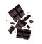 Pieces of dark chocolate falling on background