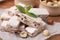 Pieces of delicious nutty nougat on white parchment paper, closeup