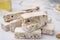 Pieces of delicious nutty nougat on white table, closeup