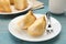 Pieces of delicious sponge cake and fork on light blue wooden table, closeup