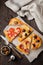 Pieces of different Greek pizzas with olives, Italian Margarita and Pepperoni on a dark wooden rustic background. Selective focus