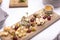 Pieces of different types of cheese with grape nuts and sauce on a wooden Board, cheese plate