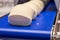 Pieces of dough on a conveyor belt. Industrial production of bread. Preparing dough for baking bread or baguettes