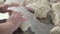 Pieces of dough lay on stainless steel working table, chef kneads dough.