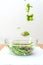 Pieces of fresh vegetables falling down into glass bowl creating healthy salad.