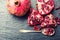 Pieces and grains of ripe pomegranate. Pomegranate seeds. Part of pomegranate fruit on granite board and antique spoon.