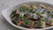 Pieces of herring fillet are sprinkled with green onions on a white plate. Salted sea fish, a traditional cold appetizer.