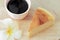 Pieces of Japanese style Cheesecake and cup of black coffee on wooden plate.