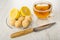 Pieces of lemon, creamy fudge in saucer, cup with tea, knife on wooden table