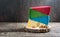 Pieces of multi-colored craft cheese lie in a stack on the rustic background.