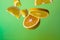 Pieces of orange steam in the air on green background. Useful fruit. Health. Diet. Citrus.