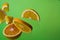 Pieces of orange steam in the air on green background. Useful fruit. Health. Diet. Citrus.
