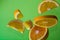 Pieces of orange steam in the air on green background. Useful fruit. Health. Diet. Citrus.