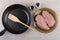 Pieces of raw chicken breast in plate, frying pan, spatula