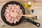 Pieces of raw chicken meat and spatula in frying pan