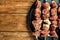 Pieces of raw meat are strung on skewers. Close-up with space for copy. View from above.