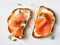 Pieces of salmon on a rectangular piece of bread spread with butter