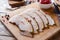 Pieces of smoked boiled pork on a wooden rustic Board with bread, sauces and spices on a wooden table