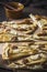 Pieces of a tarte flambee with pear, goat cheese, honey and walnuts on dark rustic wooden background