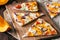 Pieces of tarte flambee with pumpkin, red onions and cheese