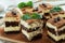 Pieces of tiramisu cake with delicate cream, coffee beans and mint leaves