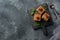 Pieces of tiramisu cake with delicate cream, coffee beans and mint leaves. Dark concrete background with copy space. Top view