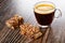 Pieces of wafer in chocolate with peanut, transparent cup with espresso on wooden table