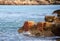 Pieces of a wall made of red brick and stones, destroyed by sea waves, a symbol of the strength of the ocean, interesting texture