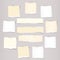 Pieces of white and beige torn note, notebook paper sheets stuck on grey background