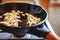 Pieces of white onion and garlic in process of frying