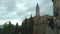 Pienza, bell tower of the Duomo and tourists on the panoramic viewpoint.