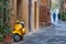 Pienza, Italy - October 13, 2017: Orange Vespa parked on old cozy street in Italy