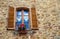 Pienza, Italy â€“ July 22, 2017: Typical italian window with shutters on a stone wall in the ancient Tuscany town Pienza.