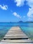 Pier at beach in Landscape of the French West Indies. The wooden bridge stretches into the sea. Beautiful tropical with Mountain