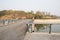 Pier bridge with fenced and tarred roadways over river in sunny