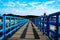 Pier with a bright blue fence in perspective. Big Red Lighthouse on the Lake Michigan. oil paint effect