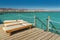 Pier with chaise longues in the sea in resort. Summer vacation. View at a clear sea with turquoise water. Summer vacation at a sea