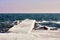 Pier in heavy ice and long icicles on stone in water