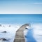 Pier or jetty on a blue ocean in the morning. Long Exposure